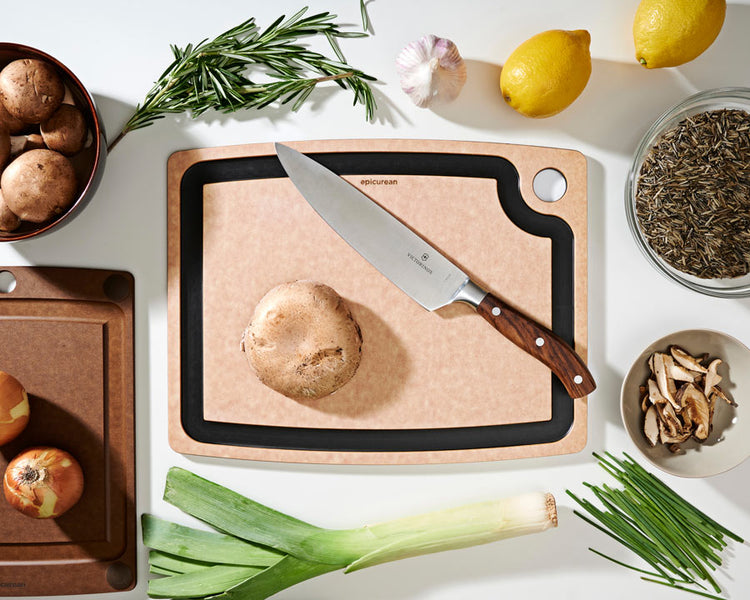 Gourmet Series Cutting Board in Natural with a Victorinox Chef's Knife Preparing To Cut Assorted Vegetables